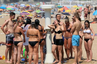 People line up to take a shower on a beach in Biarritz, in south-west France.