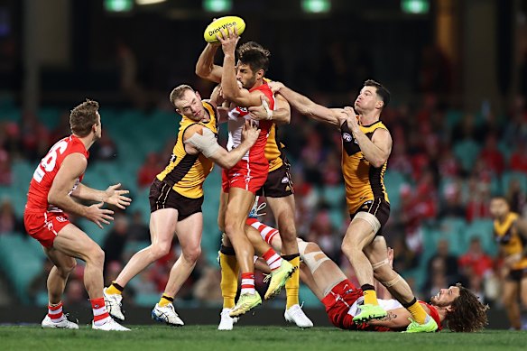 Josh Kennedy is surrounded by Hawks players.