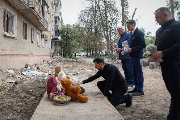 Ukrainian President Volodymyr  Zelensky, left, and British Foreign Secretary Ed Miliband, second right, at the site of a deadly attack in Pryluky on Thursday.
