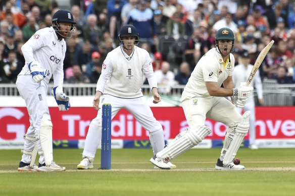 Australia’s Mitchell Marsh, right, plays a shot during the fourth day of the Old Trafford Test match.