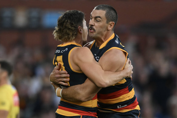 Jake Soligo of the Crows celebrates a goal with Taylor Walker of the Crows.