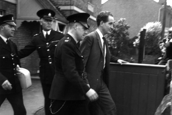 Great train robber Ronnie Biggs being escorted by three police officers in 1963.