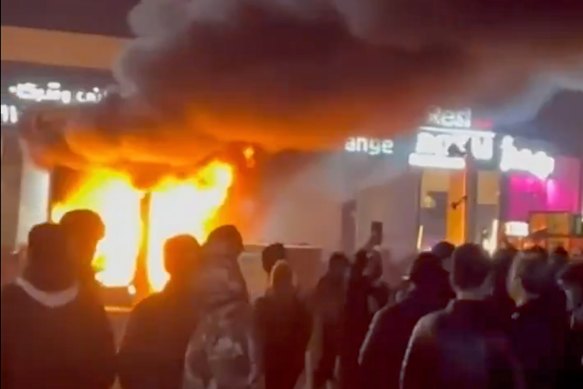 Uma captura de quadro de um vídeo mostra um incêndio enquanto pessoas protestavam em Teerã, Irã, no sábado AEDT.