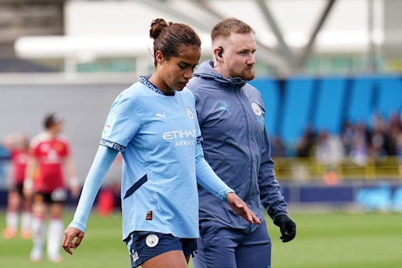 Mary Fowler leaves the field with a Man City trainer.