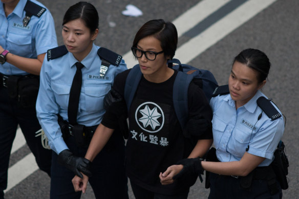 Ho, also known as singer HOCC, being escorted by police officers after a protest in 2014.