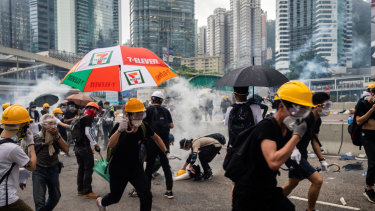 Demonstrators in Hong Kong disperse as the police fire tear gas.