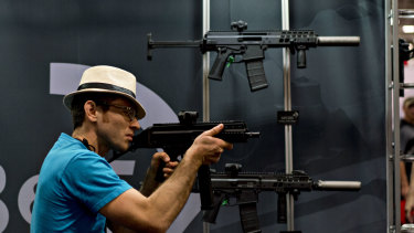 An attendee holds a rifle at the company's booth during the National Rifle Association (NRA) annual meeting in Dallas last year.