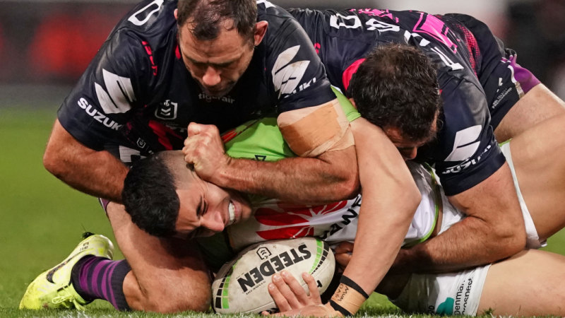 Cameron Smith appears to go to work on Canberra's Bailey Simonsson while pulling the jersey over his head.