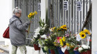 A woman prepares to lay flowers outside the Al Noor mosque in Christchurch, New Zealand in memory of the 51 people who were killed when a gunman attacked two mosques. 