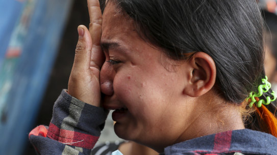 Thae Nu Naing, sister of Saw Pyae Naing weeps by his body at their home in Mandalay, Myanmar. He was shot and killed by polic eon Sunday.