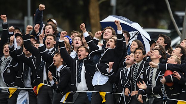 School ties: Caulfield Grammar students cheer a goal against Carey Grammar in the APS grand final.