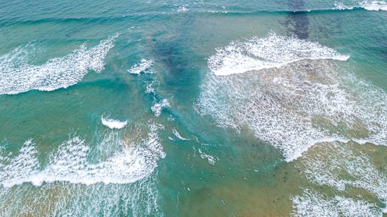 The rip is the dark water between the waves and the sandbanks.