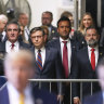 From left, North Dakota Gov. Doug Burgum, U.S. Speaker of the House Mike Johnson and businessman Vivek Ramaswamy  look on as former President Donald Trump talks to the media outside Manhattan criminal court in New York