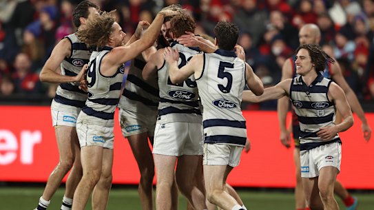 Tom Hawkins is mobbed by teammates after kicking a goal.