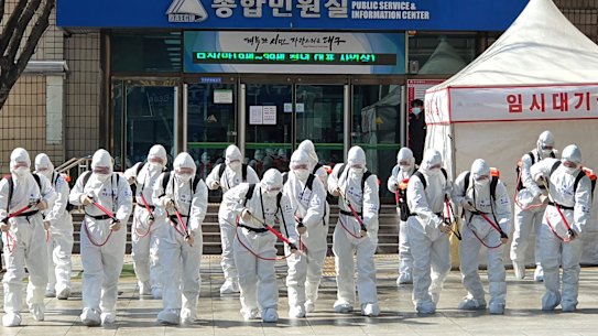 South Korean soldiers wearing protective suits spray disinfectant to prevent the spread of coronavirus in front of the Daegu city hall. 