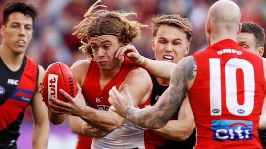 Crowded: James Rowbottom of the Swans is tackled by Dylan Clarke and the Bombers at the MCG.