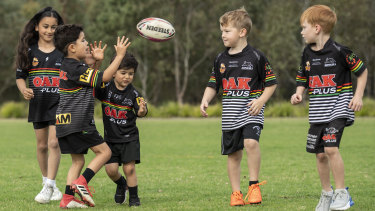 A group of young Panthers fans throw the footy around at a field in Glenmore Park.