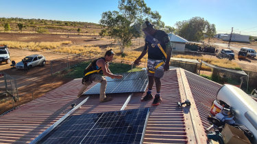 Andrew Dodd (right) learns the ropes on solar installation from Ben Hill at Tennant Creek.