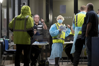 People get checked for coronavirus outside the Crossroads Hotel at Casula on Friday night.