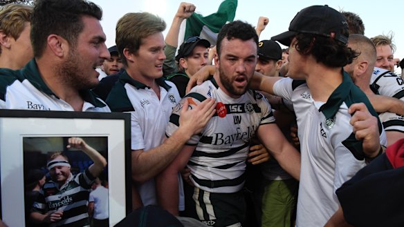 Sam Ward is surrounded by team mates after Warringah win the Shute Shield final in 2017. 