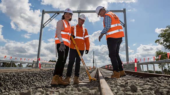 Premier Gladys Berejiklian, site manager Ben Miller and Transport and Infrastructure Minister Andrew Constance at Bella Vista, where the last sleepers for the Metro North West project were locked down.