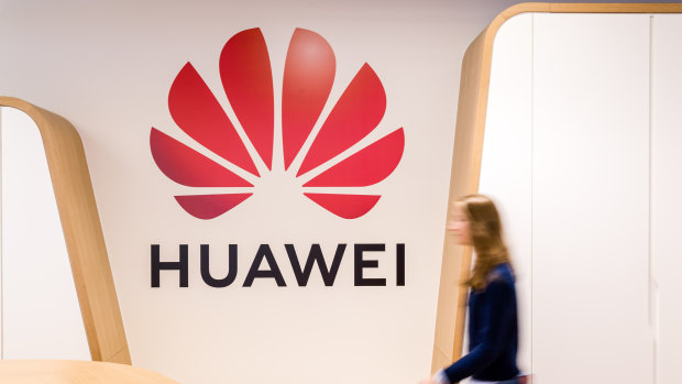 An employee walks past a logo in the reception area of the Huawei Cyber Security Transparency Centre in Brussels, Belgium.