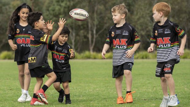 A group of young Panthers fans throw the footy around at a field in Glenmore Park.