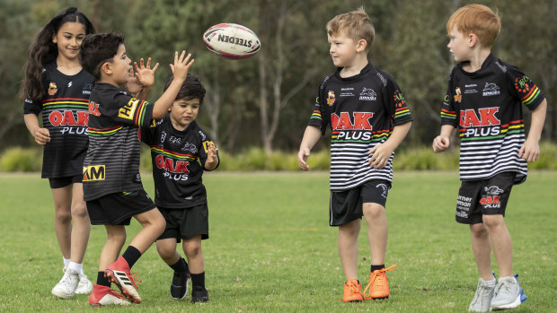 A group of young Panthers fans throw the footy around in Glenmore Park.