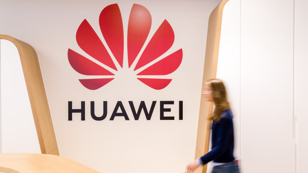 An employee walks past a logo in the reception area of the Huawei Cyber Security Transparency Centre in Brussels, Belgium.