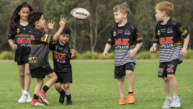 A group of young Panthers fans throw the footy around at the local ground.
