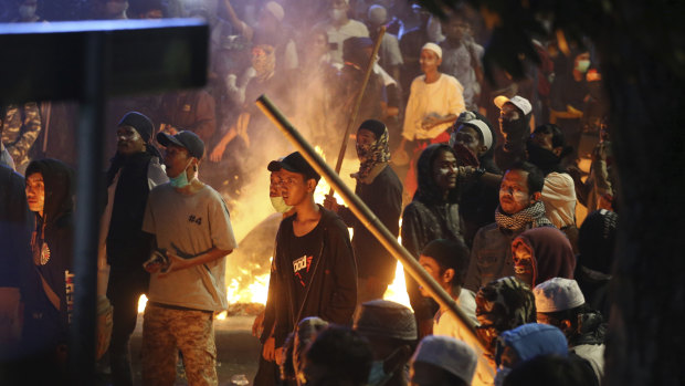 Supporters of the losing presidential candidate stand near a fire during clashes with police on Wednesday night.