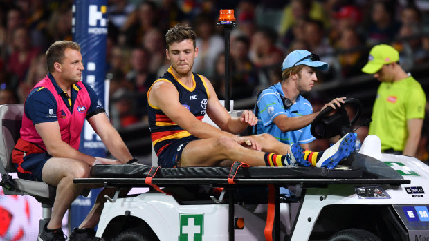 Shattered: Adelaide's Paul Seedsman is taken from the field with a suspected torn ACL.