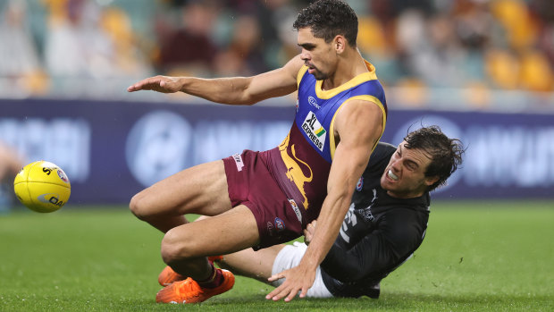 Charlie Cameron is tackled by Lachie Plowman.