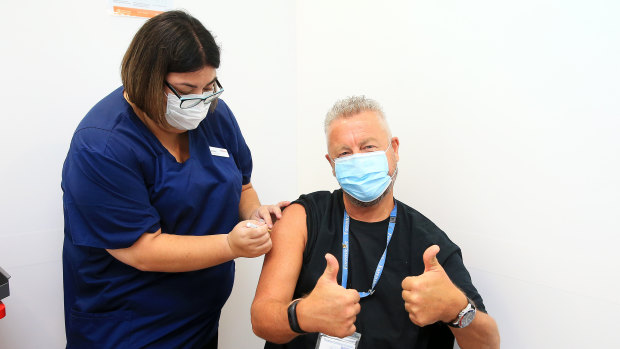 Dr Chris Quinn, who has been working in hotel quarantine, receives one of the first Pfizer COVID-19 vaccines at Austin Health in Melbourne, administered by nurse Jessica Amalfi.