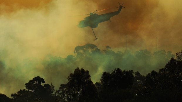 A helicopter drops water on the fire front at Barden Ridge, Sydney. 