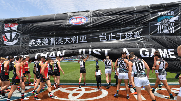 St Kilda and Port Adelaide players run through the banner before last year's match in Shanghai.
