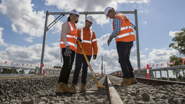 Premier Gladys Berejiklian, site manager Ben Miller and Transport and Infrastructure Minister Andrew Constance at Bella Vista, where the last sleepers for the Metro North West project were locked down.