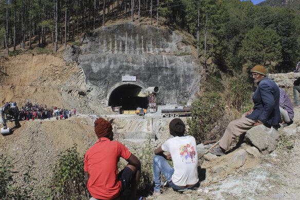 People watch rescue and relief operations at the site of an under-construction road tunnel that collapsed in mountainous Uttarakhand state, India.