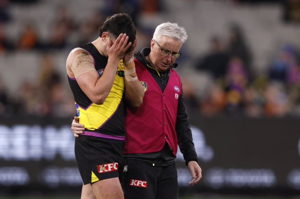 Tim Taranto of the Tigers is helped from the ground.