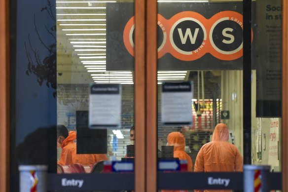 Workers in protective gear prepare to deep clean a Woolworths at Epping Plaza on Tuesday after it was listed as a tier 1 COVID-19 exposure site.