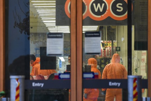 Workers in protective gear prepare to deep clean a Woolworths at Epping Plaza on Tuesday after it was listed as a tier 1 COVID-19 exposure site.