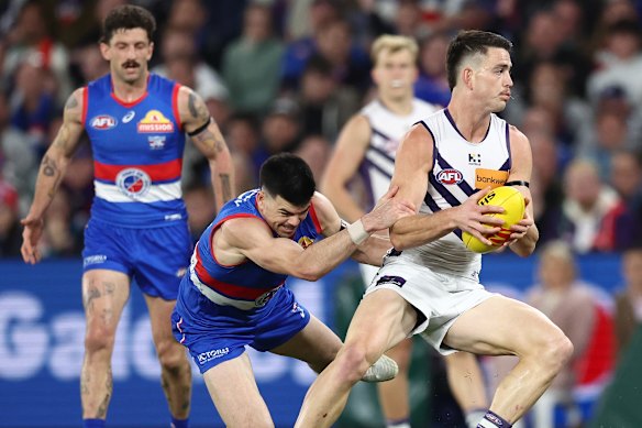 Patrick Voss of the Dockers is tackled by Matthew Kennedy of the Bulldogs during Saturday’s must-win clash.