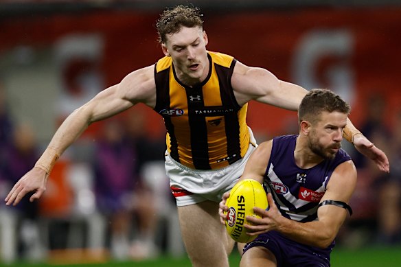 Sam Switkowski of the Dockers is chased by Josh Weddle of the Hawks.