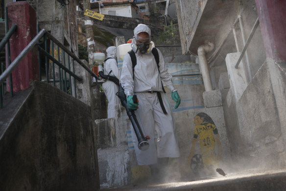 A worker sprays disinfectant in an alley to help contain the spread of coronavirus in Rio de Janeiro, Brazil.