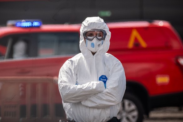 Un operatore sanitario osserva l'evacuazione dei passeggeri della MV Hondius dal porto di Granadilla a Tenerife.