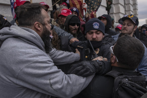 Demonstrators clash with a US Capitol police officer as they attempt to breach the Capital building on January 6.