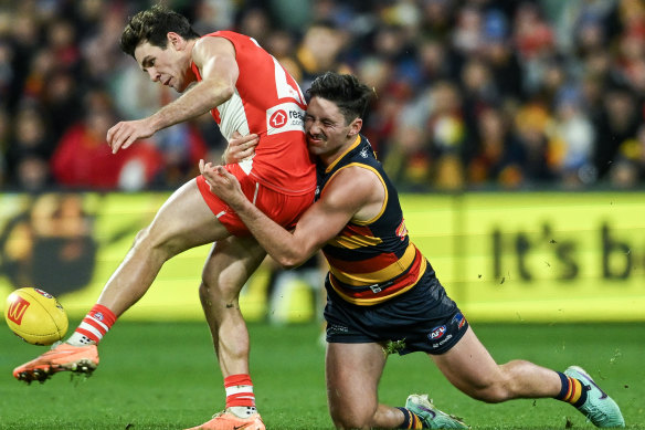 Errol Gulden of the Swans is tackled by  Chayce Jones of the Crows.