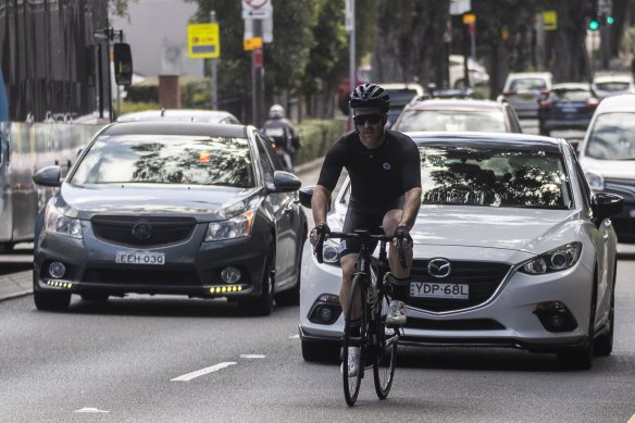 A cyclist weaves through traffic on Cleveland Street.