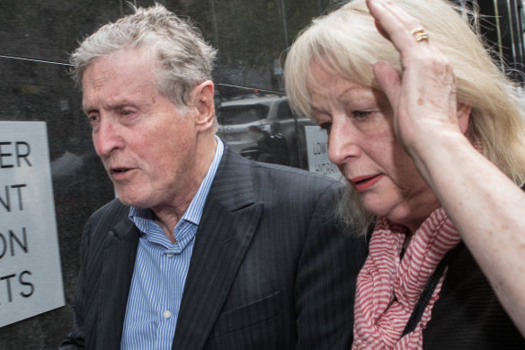 Ray Walker, head of the faux grass roots community group Save Cranbourne West, as a woman tries to shield him from cameras.
