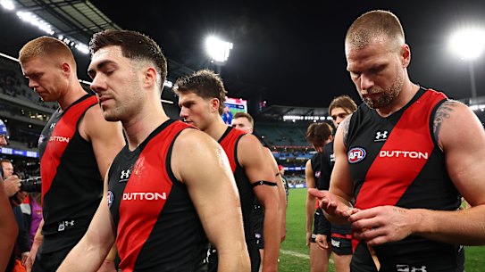 The Bombers look dejected as they leave the field following their loss.